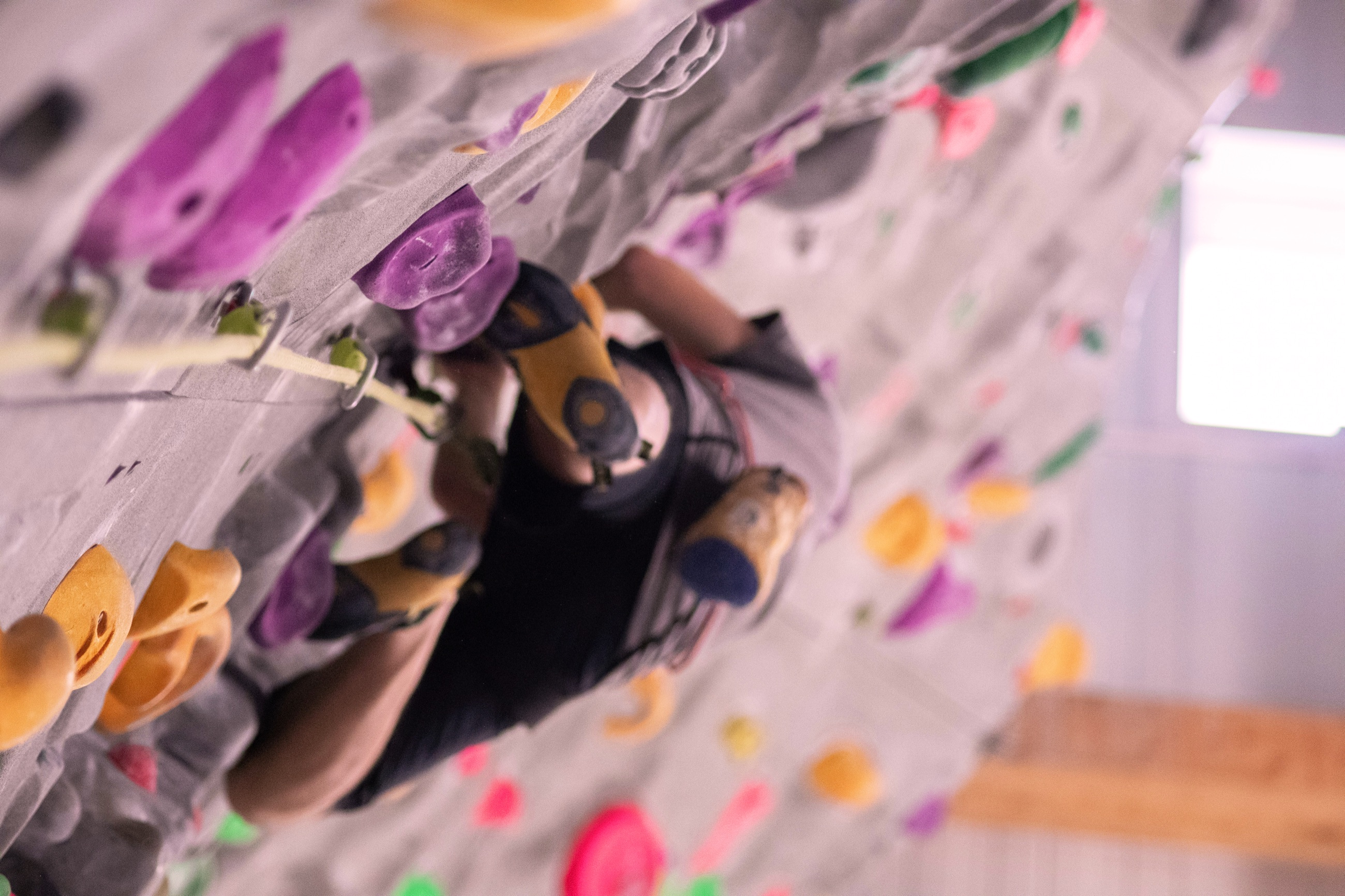 Parede de escalada indoor com agarras coloridas vista de cima